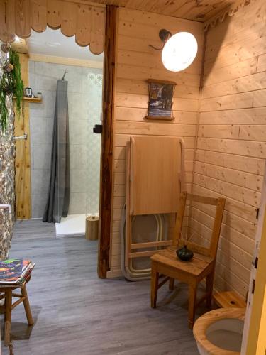 a wooden room with a chair and a shower at Les 3Crokignols, maison d’hôte familiale. in Saffloz