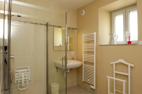 y baño con ducha acristalada y lavamanos. en Chez la francine en Noë-les-Mallets