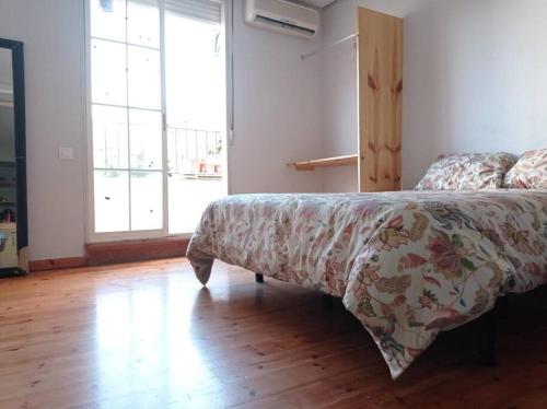 - une chambre avec un lit doté d'une couette et d'une fenêtre dans l'établissement Espectaculares vistas atico., à Carthagène