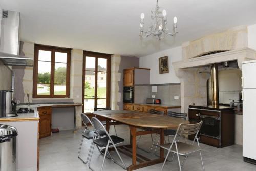 une grande cuisine avec une table et des chaises en bois dans l'établissement Les perrieres, aux Riceys
