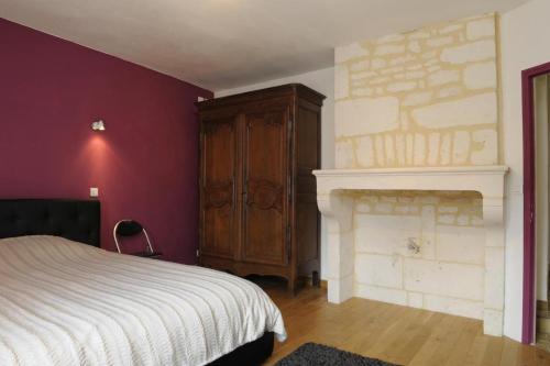 ein Schlafzimmer mit einem Bett und einem Kamin in der Unterkunft Les perrieres in Les Riceys