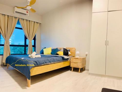 een slaapkamer met een bed en een groot raam bij JQ Citypads by Golden Stay in Kota Kinabalu