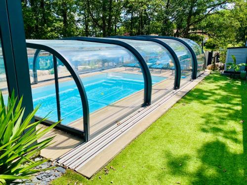 - une piscine sous une arche dans une cour dans l'établissement Logement 2 chambres proche MEETT & aéroport, à Aussonne