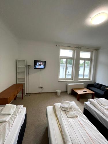 a room with three beds and a flat screen tv at Monteurwohnung am Holstein-Center in Itzehoe