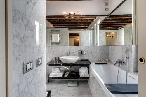 a bathroom with a tub and a sink and a bath tub at Hotel Santa Marta Suites in Milan