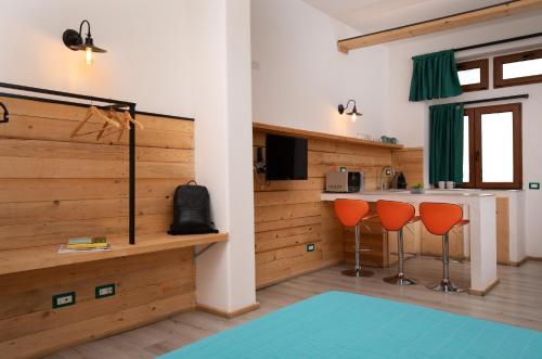 una cocina con 2 sillas naranjas y una barra en OlbiaLoft, en Olbia