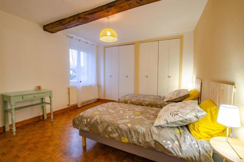 a bedroom with a bed and a table and a desk at Le gite de saint martin in Mailly-le-Camp