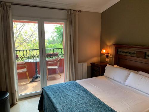 Hotel Villa San Francisco في مربلة: غرفة نوم مع سرير وبلكونة مع طاولة