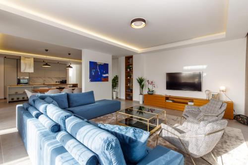 a living room with a blue couch and a tv at Luxury Villa Eleven near Rovinj for 10 persons only 4 km from the Beach in Rovinjsko Selo