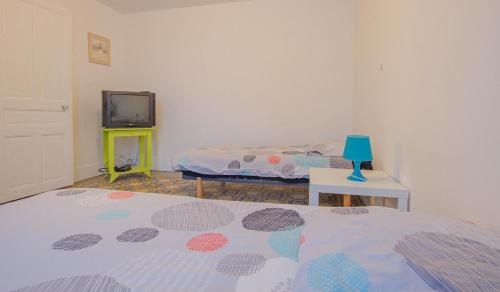 ein Schlafzimmer mit 2 Betten und einem TV. in der Unterkunft L'arminda in Champfleury