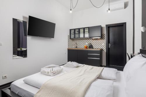 a bedroom with a large bed with white sheets at Molo Longo - Downtown Apartments in Rijeka