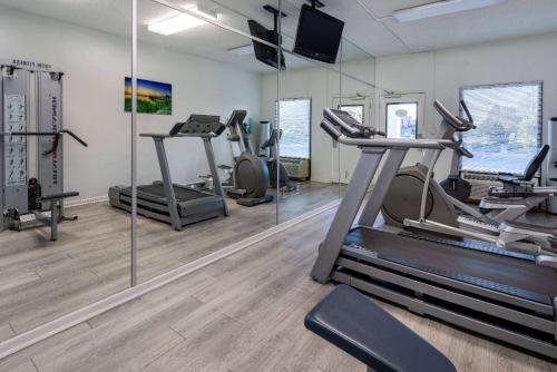 een fitnessruimte met loopbanden, elliptische machines en spiegels bij Studio 6 Suites Jacksonville, NC in Jacksonville