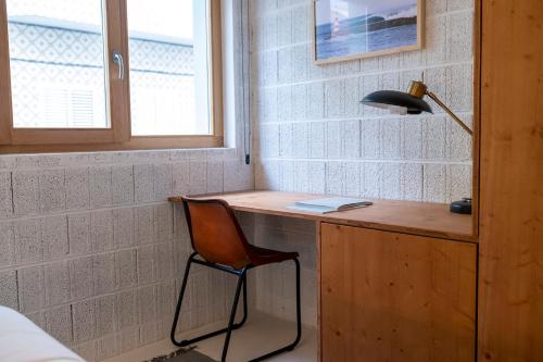 einen Schreibtisch mit einem Stuhl und einer Lampe in einem Zimmer in der Unterkunft Fisherman's Blues - Casa na Praia in Arcozelo