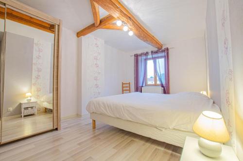 - une chambre avec un grand lit et un miroir dans l'établissement Le gite de la boderonne, à Villy-en-Trodes