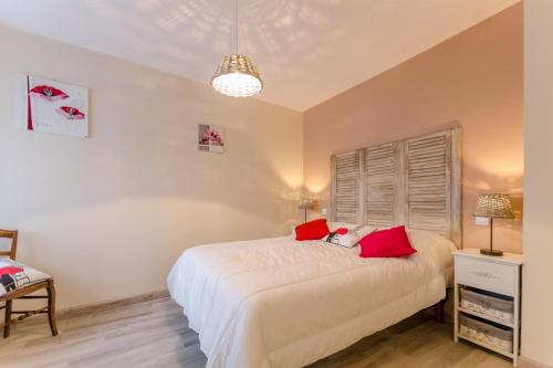 a bedroom with a white bed with red pillows at La menuiserie du pre in Rigny-la-Nonneuse
