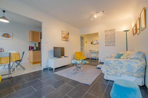 un salon avec un canapé et une télévision dans l'établissement Le saint michel, à Troyes