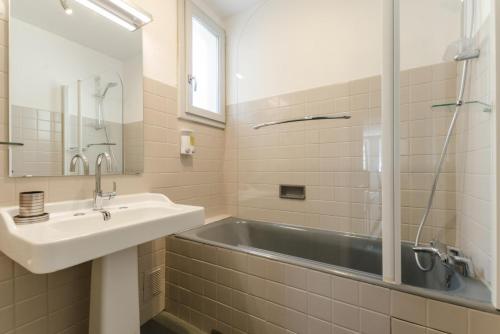 een badkamer met een bad, een wastafel en een spiegel bij Le gite de tatanne in Villenauxe-la-Grande