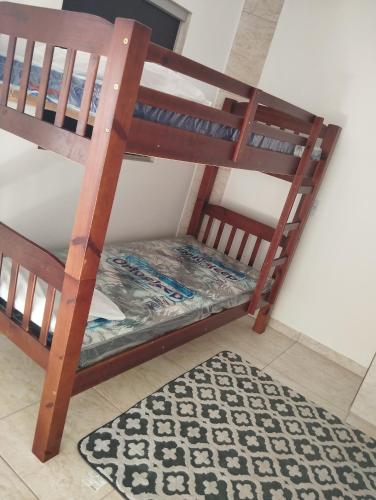 a set of bunk beds in a room with a rug at Pausada do Gilmar in Ribeirão