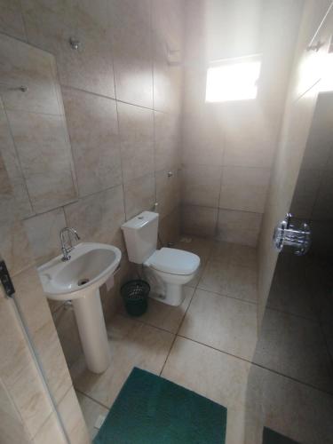 a bathroom with a toilet and a sink at Pausada do Gilmar in Ribeirão