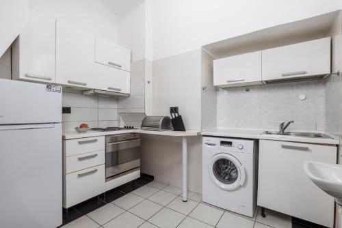 a white kitchen with a washing machine and a sink at Molo Longo - Downtown Apartments in Rijeka