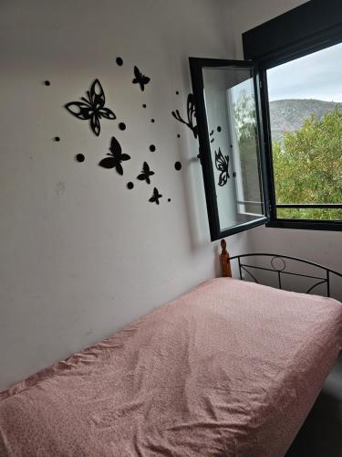 1 dormitorio con mariposas en la pared junto a la cama en Near Moraira Apartment in Benitachell 2, en Benitachell