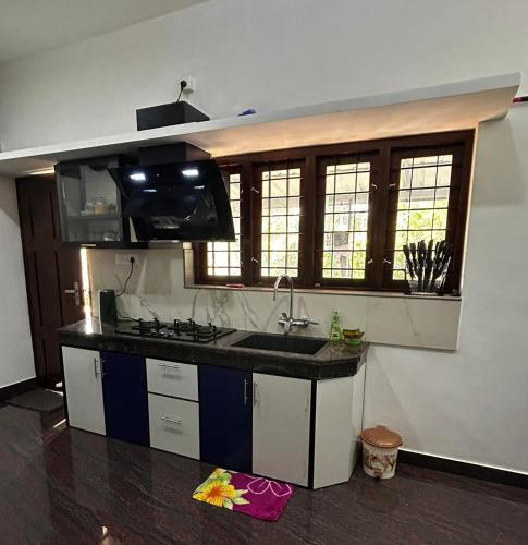a kitchen with a sink and a counter top at Windgram Homestay in Ambalavayal