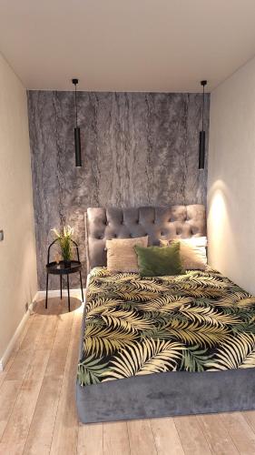- une chambre avec un grand lit et une grande tête de lit dans l'établissement Apartamentai su balkonu prie Akropolio Nr 2, à Klaipėda