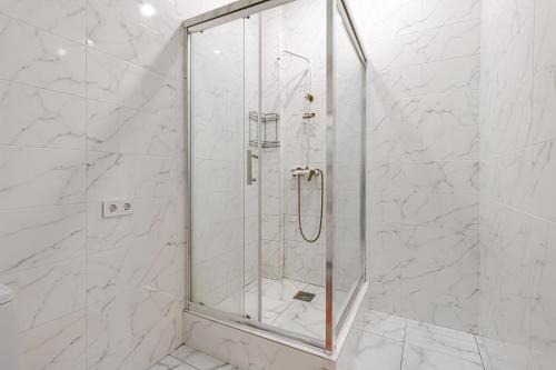 een douche met een glazen deur in de badkamer bij Комфортабельная квартира в ЖК Apple City in Astana