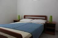 a bedroom with a blue bed with two green candles at Apartments Lampion in Vir