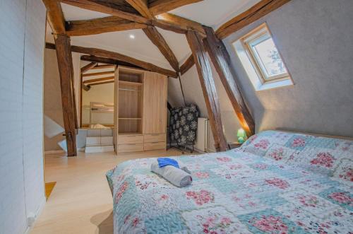 1 dormitorio con 1 cama en una habitación con vigas de madera en Gite de la bouvotte, en Neuville-sur-Vanne