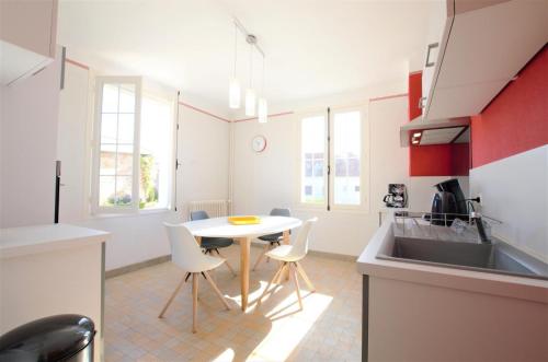 une cuisine avec une table, des chaises et un évier dans l'établissement Les libellules, à Magnicourt