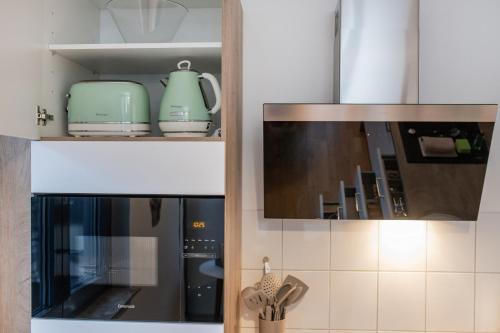 a kitchen with some utensils in a cabinet at EASYLIFE - Apartment Retro in Eisenach