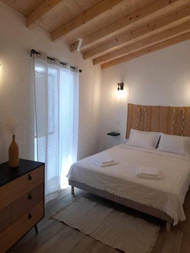 a bedroom with a bed and a dresser and a window at Alqueive GUEST HOUSE in Alqueva