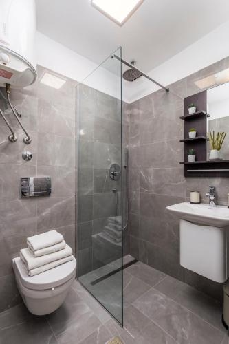 a bathroom with a shower and a toilet and a sink at Molo Longo - Downtown Apartments in Rijeka