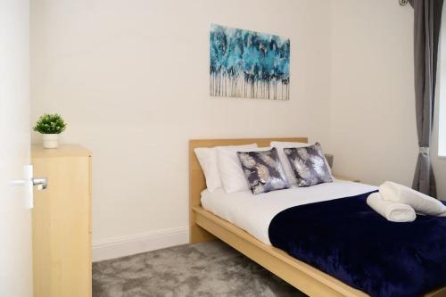 a bedroom with a bed and a painting on the wall at Aqua Springs, luxury 2 bed, 2 bath apartment, near Didsbury in Manchester