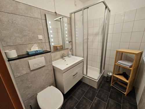 ein Bad mit einem WC, einem Waschbecken und einer Dusche in der Unterkunft FEWO FAUBEL Mülheim Forum City 60 m2 in Mülheim an der Ruhr