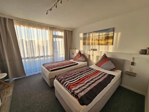 ein Hotelzimmer mit 2 Betten und einem Fenster in der Unterkunft FEWO FAUBEL Mülheim Forum City 60 m2 in Mülheim an der Ruhr