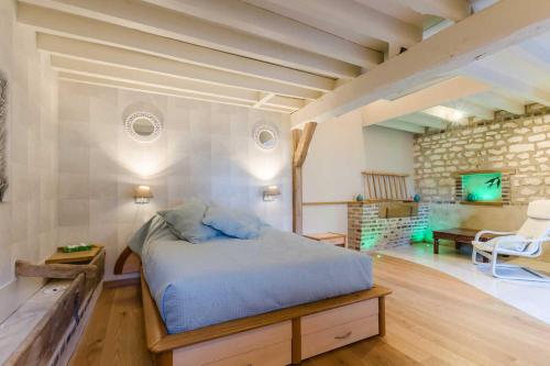 EstissacにあるLa maisonnetteの石壁のベッドルーム1室(ベッド1台付)