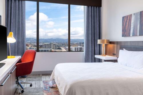 a hotel room with a bed and a desk and a window at Hilton Garden Inn San Francisco/Oakland Bay Bridge in Emeryville