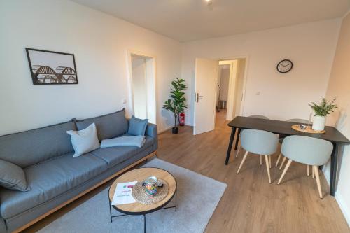 ein Wohnzimmer mit einem Sofa und einem Tisch in der Unterkunft RR - Stylish Apartment 50qm - WIFI - Washer - TV in Magdeburg