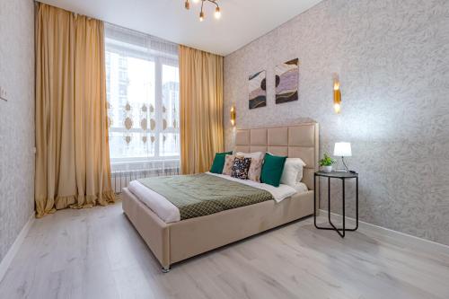 een slaapkamer met een bed en een groot raam bij Комфортабельная квартира в ЖК Apple City in Astana