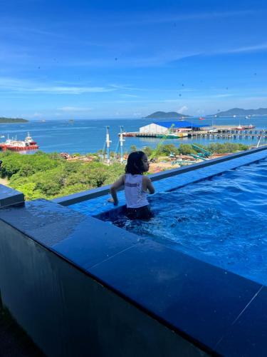 a little girl sitting in a swimming pool at JQ Citypads by Golden Stay in Kota Kinabalu