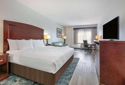 Habitación de hotel con cama, escritorio y TV. en La Quinta by Wyndham Fort Worth NE Mall en Hurst