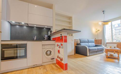 une cuisine avec une cuisinière et une machine à laver dans l'établissement Pommes et fraises, à Troyes