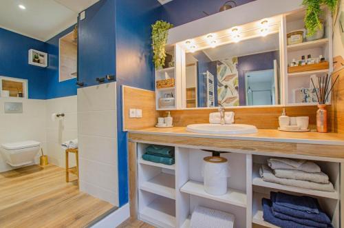 ein Bad mit einem Waschbecken und einem Spiegel in der Unterkunft Gite de l'entente in Macey