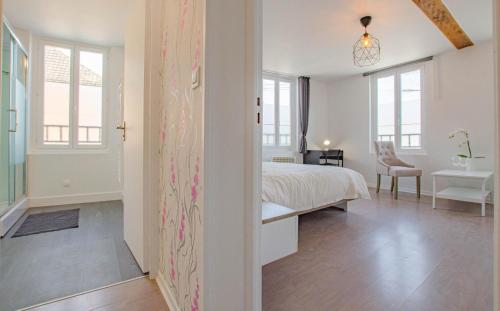 a white bedroom with a bed and a desk at Bulles des lacs in Montieramey