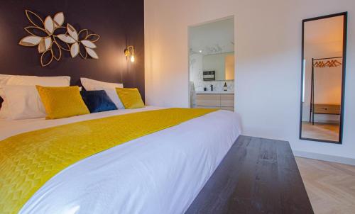 a bedroom with a large bed with yellow and blue pillows at Le beurillon in Spoy