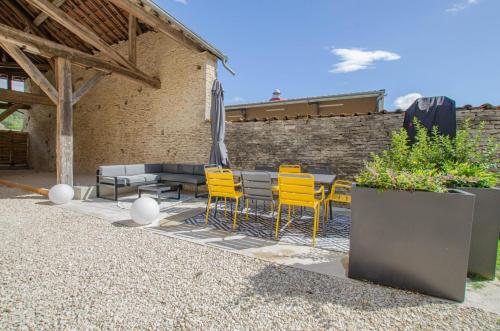 a patio with chairs and a table with an umbrella at Le beurillon in Spoy