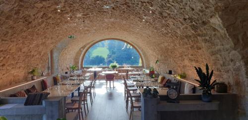 a dining room with tables and chairs and a large window at Château De La Bûcherie in Saint-Cyr-en-Arthies