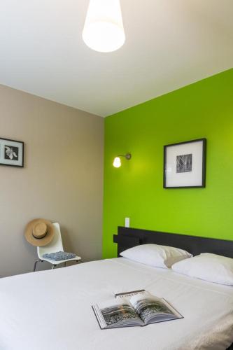 a bedroom with a green wall and a bed at La goutte d'or in Baroville
